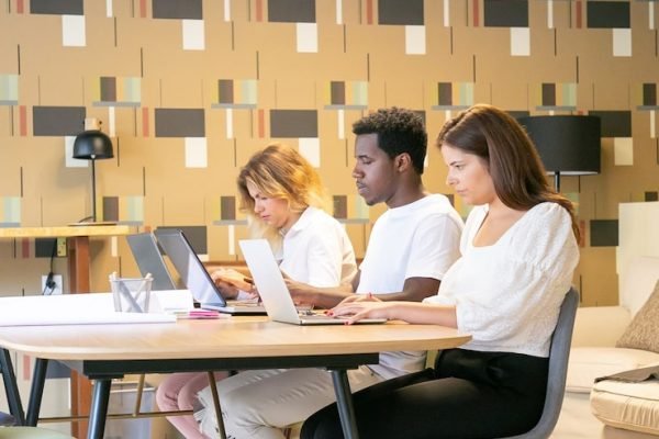 creative-team-sitting-together-table-with-blueprints-working-project_74855-9771